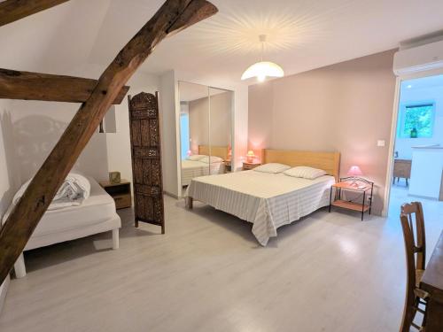 una camera da letto con due letti e uno specchio di Maison spacieuse avec terrasse couverte et parking en région naturelle - FR-1-591-764 a Méobecq