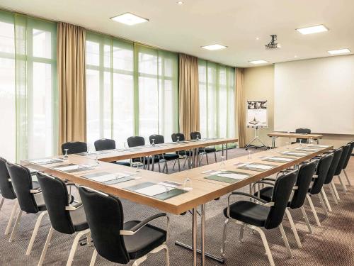 a large conference room with a long table and chairs at Mercure Hotel Düsseldorf City Center in Düsseldorf
