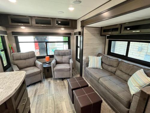 a living room with a couch and chairs in a rv at Comfortable 1BR RV for mid-to-long term stays in Beaumont