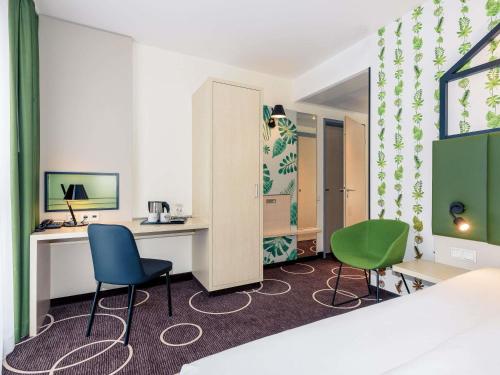 a hotel room with two chairs and a desk at Mercure Hotel Hannover Mitte in Hannover