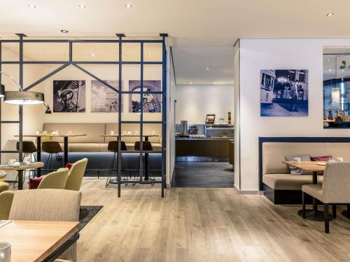 a restaurant with tables and chairs in a room at Mercure Hotel Hannover Mitte in Hannover