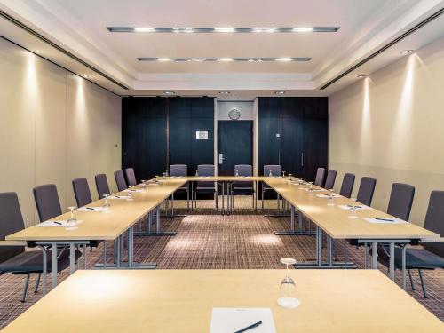a conference room with a long table and chairs at Mercure Hotel Hannover Mitte in Hannover