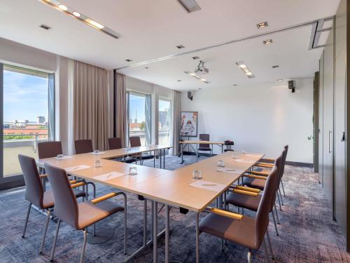 a conference room with a long table and chairs at Mercure Hotel Hannover Mitte in Hannover
