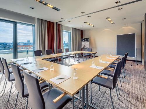 a conference room with a long table and chairs at Mercure Hotel Hannover Mitte in Hannover