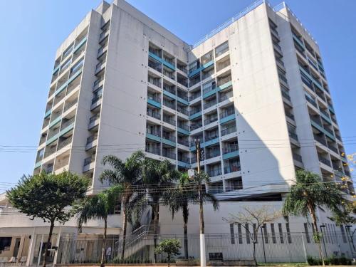 a tall white building with palm trees in front of it at Wise SP Expo Center e Anhembi in Sao Paulo
