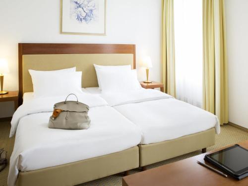 a hotel room with a bed with a bag on it at Novotel Hildesheim in Hildesheim