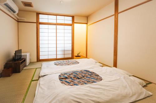 a bedroom with two beds in a room with a window at みずほガーデンロッジ in Kyotamba