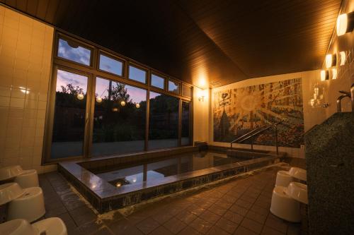a large bathroom with a jacuzzi tub with a window at みずほガーデンロッジ in Kyotamba