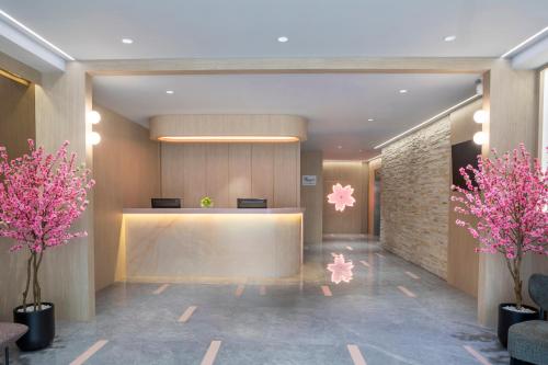 a lobby with a reception desk and pink flowers at Hotel Sakura by Venue in Singapore