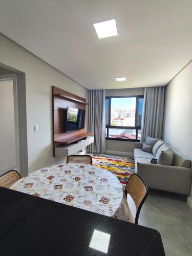 a room with a table and chairs and a living room at Apartmento em Castelhanos-Es in Anchieta