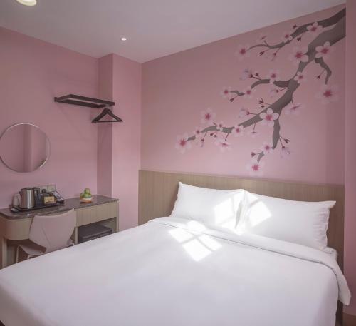 a bedroom with a white bed and a pink wall at Hotel Sakura by Venue in Singapore