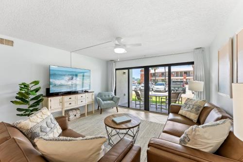 a living room with two couches and a tv at Sandcastles 413 in Cocoa Beach