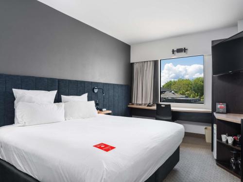 a hotel room with a large bed and a window at ibis Rotorua in Rotorua