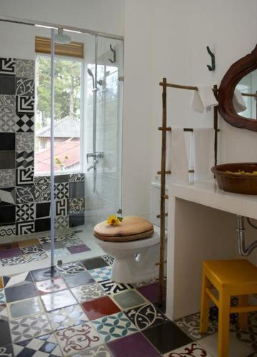 a bathroom with a toilet and a glass shower at Stop and Go Boutique Hotel in Da Lat