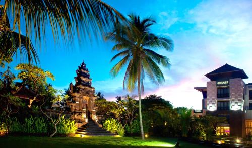 a palm tree and stairs in front of a building at Pullman Bali Legian Beach in Legian