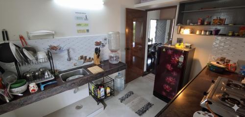 a small kitchen with a counter and a refrigerator at The Sparrow in Kanyakumari