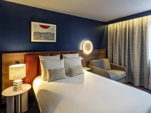 Un pat sau paturi într-o cameră la Mercure Caen Cote De Nacre