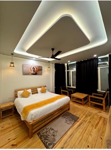 a bedroom with a large bed with a ceiling fan at Varlaxmi Vatika in Rānīkhet