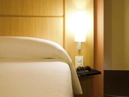 a bedroom with a bed and a light on a wall at ibis Recife Boa Viagem in Recife
