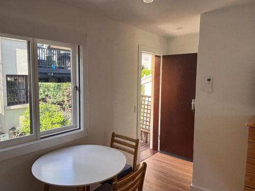 a dining room with a white table and a window at Studio granny flat in Sydney