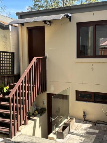 a house with a staircase and a glass door at Studio granny flat in Sydney