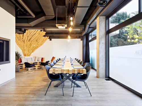a conference room with a long table and chairs at Mercure Biel in Biel