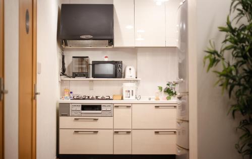 a kitchen with a stove and a microwave at 锦·【金太閣】名古屋駅徒歩700m超大空间まるまる貸切 in Nagoya