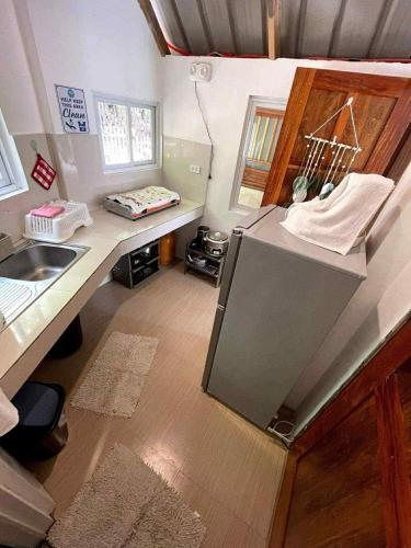 a bathroom with a sink and a tv in a room at CABIN C at Bigang Munti Beach Resort in Bootin