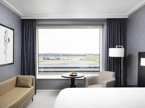 a hotel room with a bed and a large window at Sofitel London Gatwick in Horley