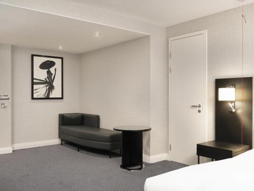 a room with a bed and a chair and a table at Sofitel London Gatwick in Horley