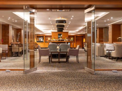 a dining room with a table and chairs at Sofitel London Heathrow in Hillingdon
