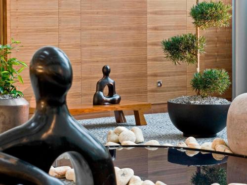 a statue of a woman sitting on a table with plants at Sofitel London Heathrow in Hillingdon