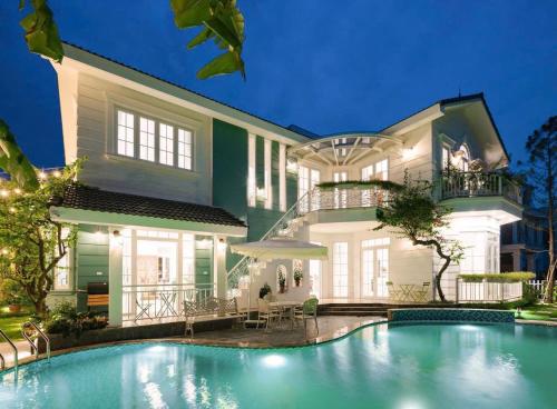 ein großes Haus mit einem davorliegenden Swimmingpool in der Unterkunft Villa B82 Flamingo Đại Lải Resort in Phúc Yên