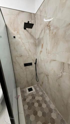 a bathroom with a shower with a tiled floor at The cozy spot negril in Negril
