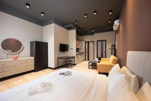 a bedroom with a large white bed and a living room at Elegant space Studio by Spacey Duqm 82 in Duqm
