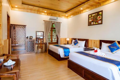a hotel room with two beds and a table at Bungalow Sáng Tươi Mountains in Phu Quoc