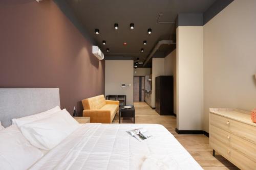 a bedroom with a white bed and a chair at Luxury home away Studio by Spacey Duqm 81 in Duqm