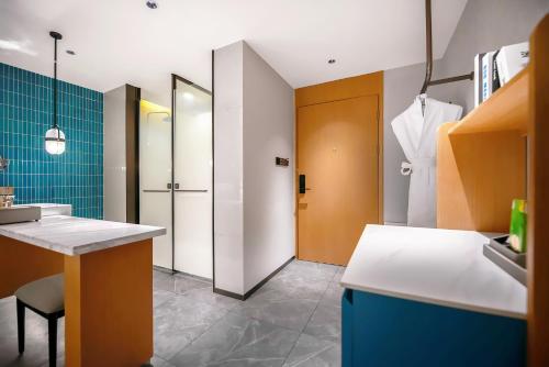 a bathroom with a sink and a shower with a robe at Rosewood Chengdu in Chengdu