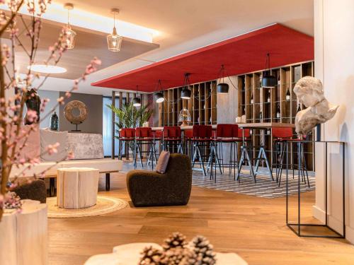 a lobby with a bar with red stools at Mercure Valence in Valence
