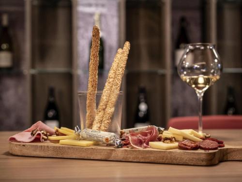 a plate of cheese and meats and a glass of wine at Mercure Valence in Valence
