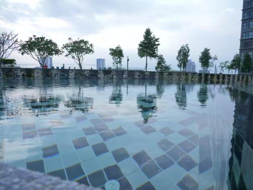 ein Wasserpool mit einer Stadt im Hintergrund in der Unterkunft Chic & Cozy Studio - HYVE SOHO Cyberjaya in Cyberjaya