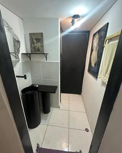 ein Badezimmer mit einer schwarzen Tür und einem schwarzen Waschbecken in der Unterkunft Casa das artes Pinheiros in São Paulo