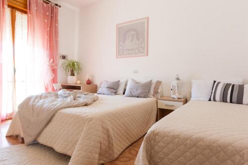 a bedroom with two beds and a window at Villa dei Fiori Apartments in Cervia