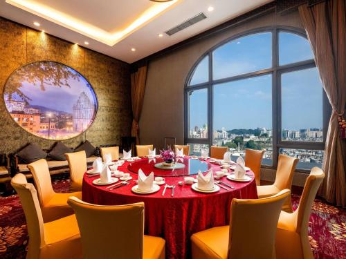 a restaurant with a table and chairs and a large window at Sofitel Macau At Ponte 16 in Macau