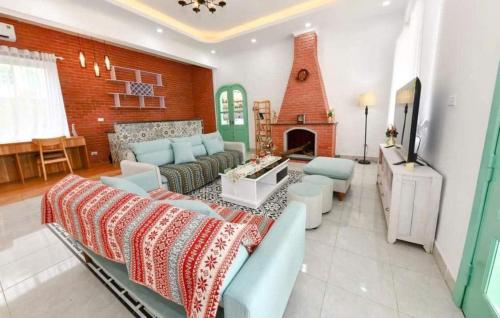 een woonkamer met een bank en een open haard bij Solaria Garden Sóc Sơn in Sóc Sơn