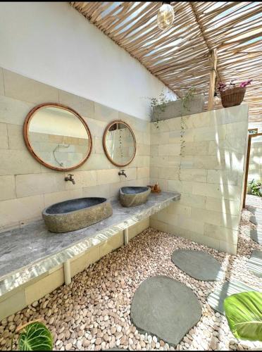 a bathroom with two sinks and two mirrors at Elisa Hostel in Kuta Lombok