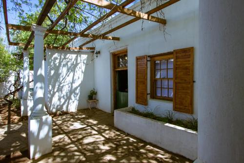 a house with a pergola and a door and window at The Barracks in Colesberg
