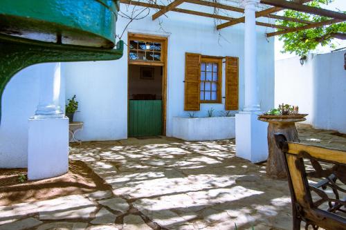 a courtyard of a white building with a green door at The Barracks in Colesberg