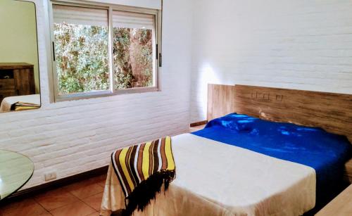 サンタ・テレサにあるCampito de Raúl, Eventos para 100 personas y alojamientoのベッドルーム1室(ベッド1台、窓、テーブル付)