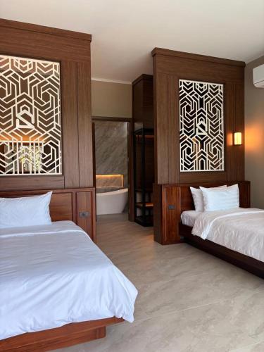 a bedroom with two beds and a bath tub in it at Song View Pool Villa in Vang Vieng